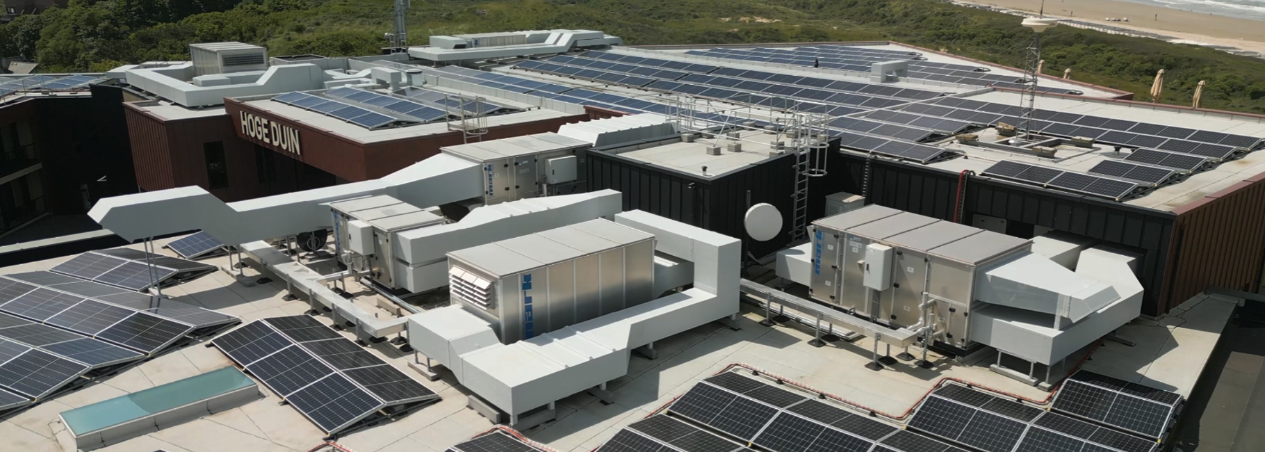 Aerial view beach hotel with solar panels and air handling units